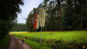 Geographischer Mittelpunkt Frankens, der sich im Steigerwald befindet Nähe Ochsenschenkel. Fahnen, Wald und Wiesen