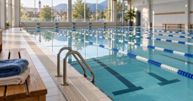 Leeres Hallenbad mit Bahnleinen und ruhigem Wasser, Symbolbild für die Öffnungszeiten in Burgebrach