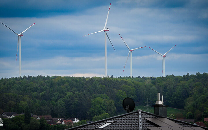 Vier Windräder bei Mühlhausen ragen über dem Steigerwald im Landkreis Erlangen-Höchstadt hervor.
